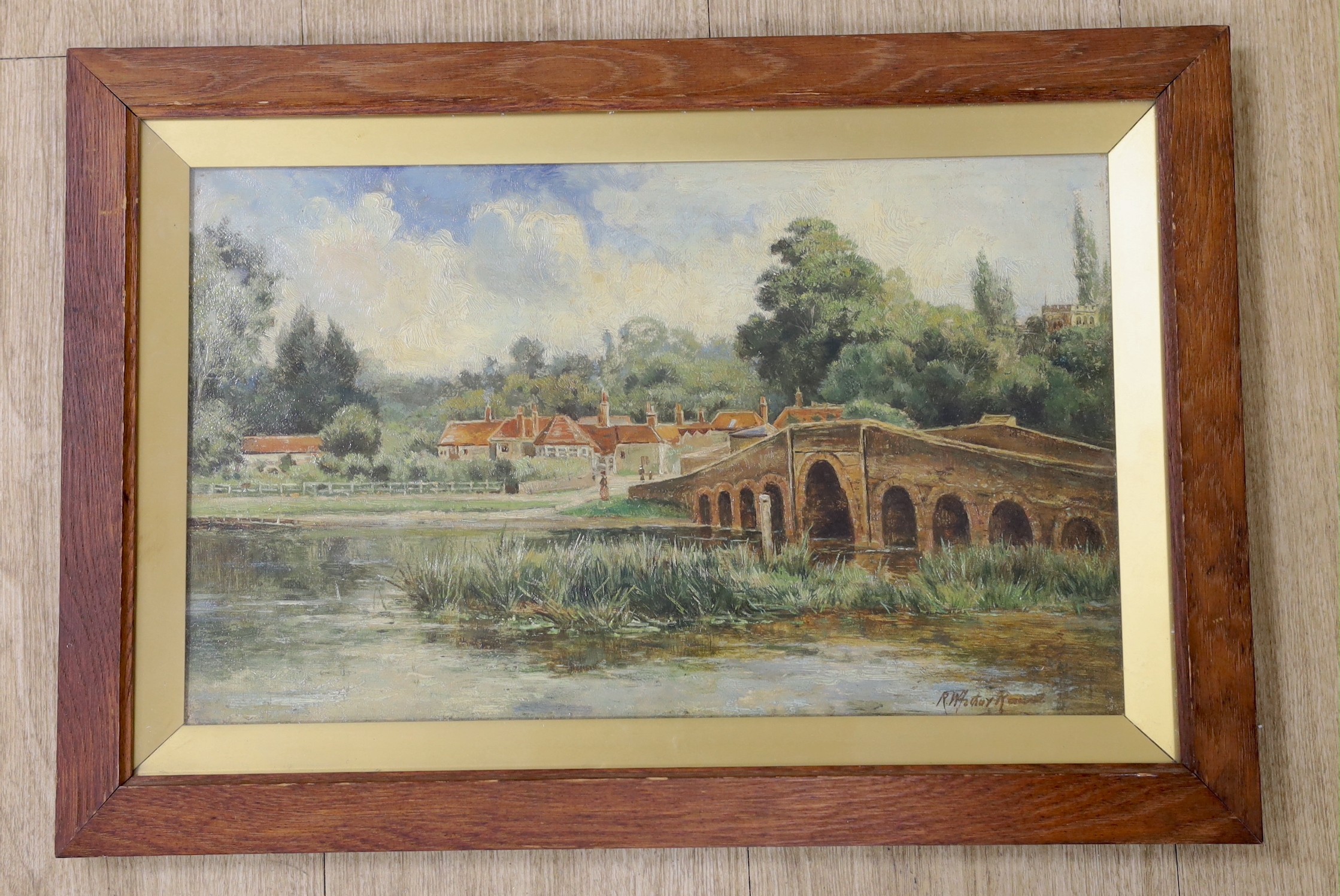 English School, early 20th century, oil on canvas, village scene with bridge, indistinctly signed, 24 x 39cm